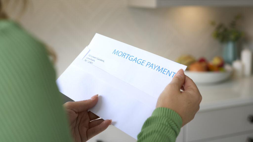 close up of a woman opening a letter about her mortgage payment being paid off by financing and mortgage prepayment